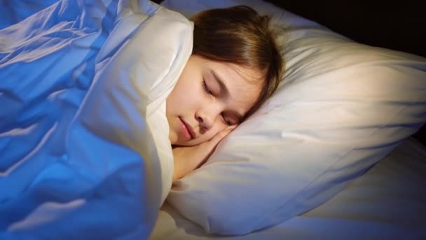 La jolie adolescente fait une sieste au lit, voit un sommeil agréable et sourit. — Video