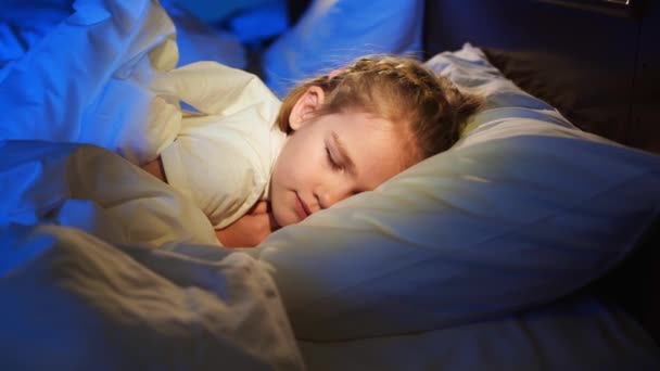 Das hübsche Mädchen schläft im Bett, sieht einen angenehmen Schlaf und lächelt. — Stockvideo