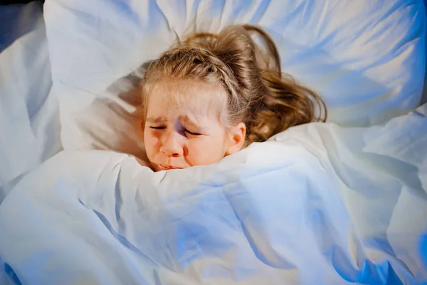 탑 뷰. 어린 소녀는 겁에 질려 침대에 누워 있다. 유아들은 두려워 한다. — 스톡 사진