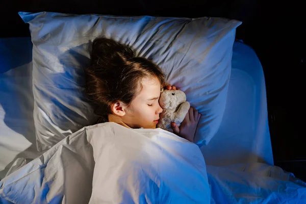 Vista dall'alto. La bella adolescente dorme con un peluche giocattolo, vede un sonno piacevole. — Foto Stock