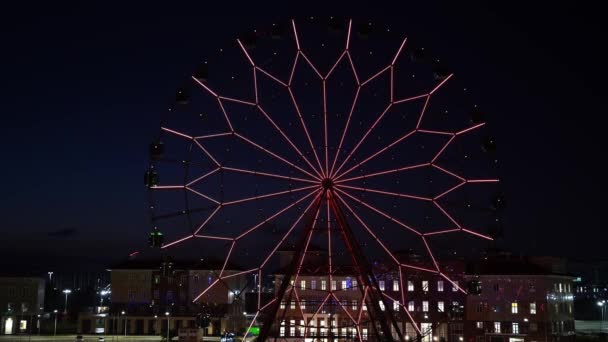 Ferris wiel met gloeiende veelkleurige lichten tegen de nachtelijke hemel. — Stockvideo