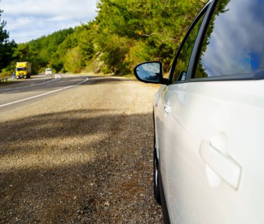 Otoyolun kenarındaki beyaz bir arabanın dikiz aynası. yol yolculuğu.