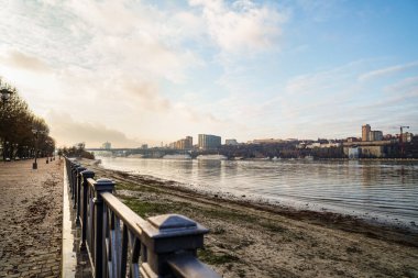 Rıhtımdaki çit. Nehrin karşısındaki şehir manzarası. Şehir manzarası