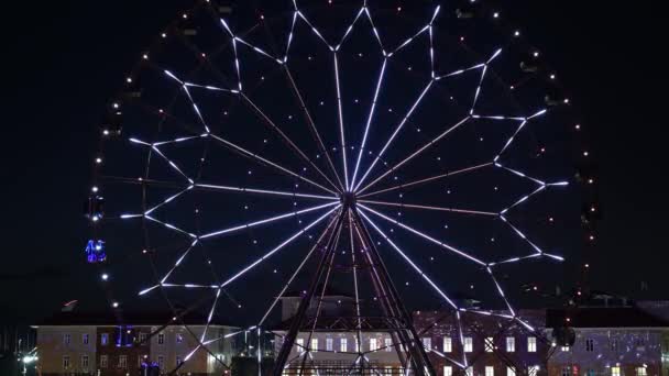 Τροχός Ferris με λαμπερά πολύχρωμα φώτα ενάντια στο νυχτερινό ουρανό. — Αρχείο Βίντεο