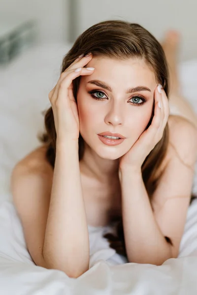 Fecha. retrato de mulher bonita com cabelos longos em roupa interior deitada na cama. — Fotografia de Stock