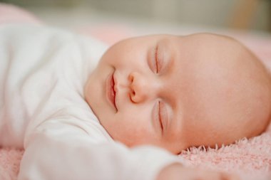 Pembe battaniyenin altında uyuyan bebek. Yeni doğanlar için sağlıklı uyku.