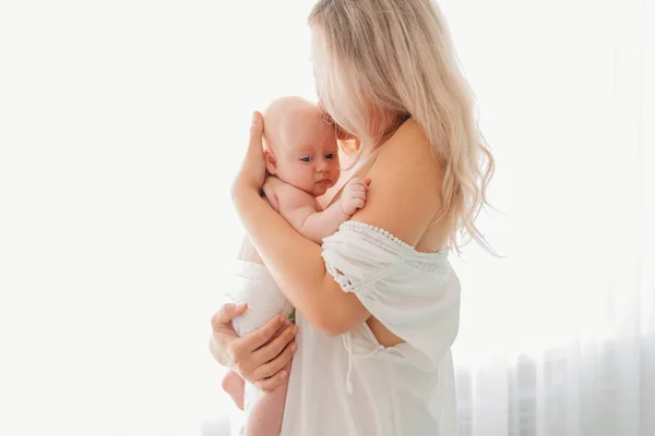 Anne ve bebek pencerede duruyor. Emzirdikten sonra..