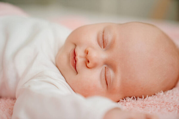 спящего ребенка под розовым одеялом. здоровый сон у новорожденных.