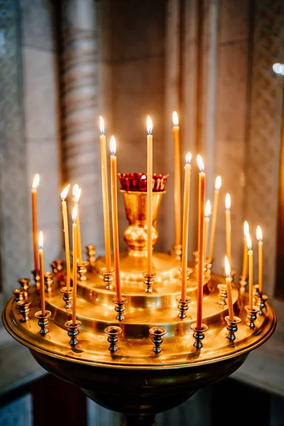 En ljusstake med många ljus i kyrkan. — Stockfoto