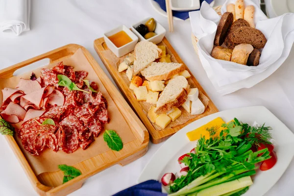 가벼운 고기 스낵, 다양 한 치즈, 올리브와 함께 식탁에 내놓는 모습. — 스톡 사진
