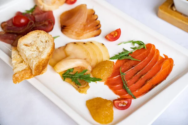 흰 접시 위에 다양 한 소금을 친 생선. 식탁에 놓인 간식들. — 스톡 사진