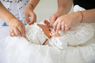 Ebeveynler yeni doğmuş bir bebeği kundaklar. Uzun zamandır beklenen çocuklu bir adam ve bir kadın..