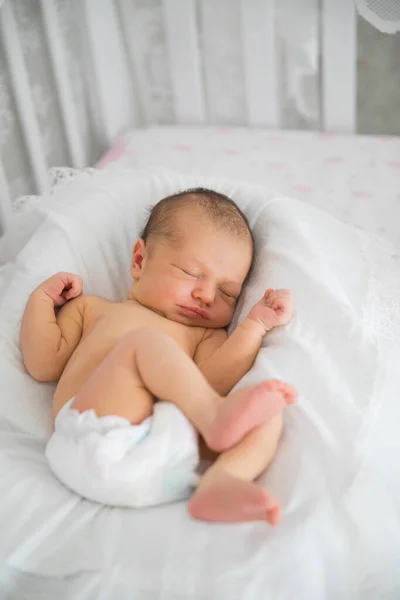 newborn sleeps in white crib. concept of healthy childrens sleep.