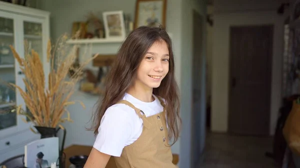 Девочка-подросток с темными длинными волосами на кухне дома. — стоковое фото