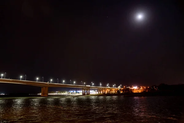 Спокойной ночи. Дорожный мост через реку с огнями. — стоковое фото