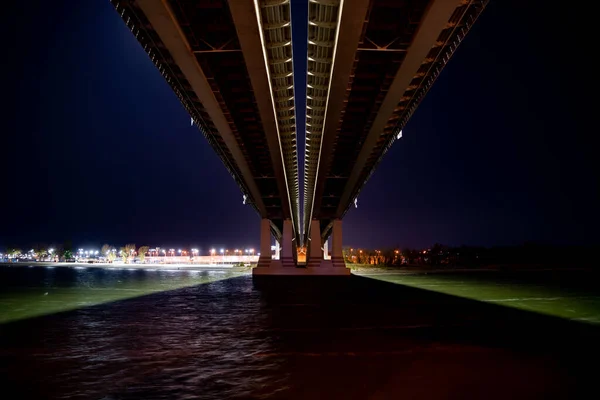Nacht. Straßenbrücke über den Fluss mit Lichtern. — Stockfoto