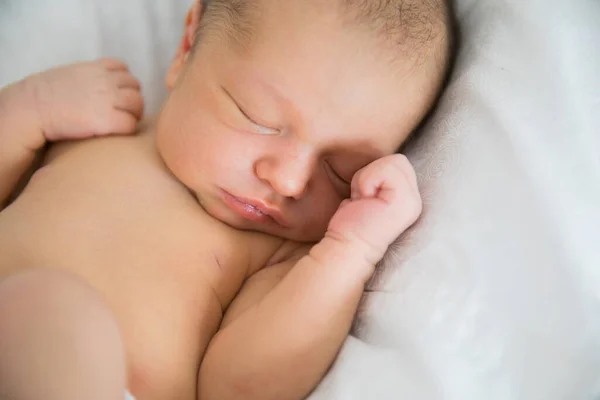 På nära håll. en nyfödd sover i en vit spjälsäng. begreppet friska barn sömn — Stockfoto