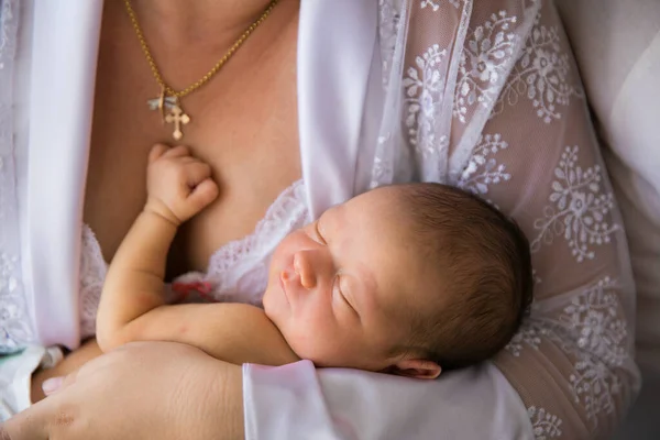 De cerca. un recién nacido duerme en brazos de su madre. —  Fotos de Stock