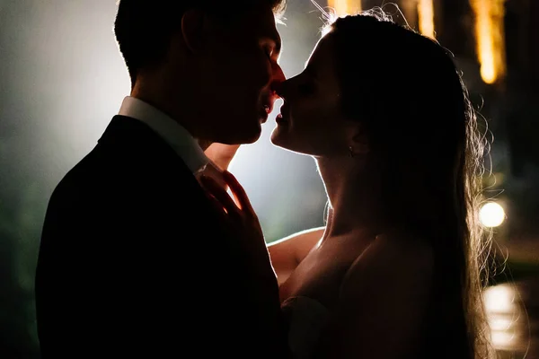 Siluetas de un hombre y una mujer enamorados en la oscuridad. romance. — Foto de Stock