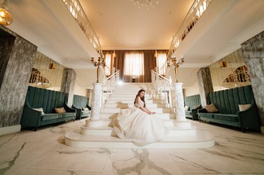 Salonda kocaman beyaz merdivenleri olan güzel gelin..