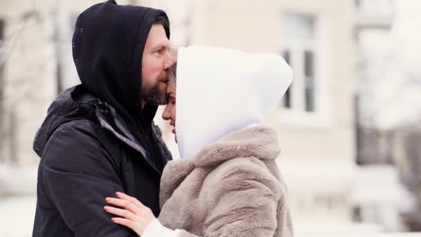Vacker man och kvinna på vintern på gatan frös och sätta på huvor. — Stockvideo