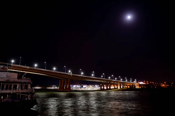 Buenas noches. puente de carretera sobre el río con luces. — Foto de Stock