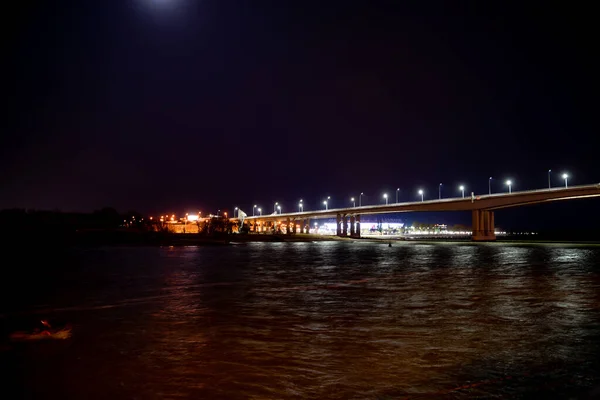 Спокойной ночи. Дорожный мост через реку с огнями. — стоковое фото