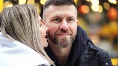 Yakın plan. Erkek ve kadın kış fotoğraf çekimi için sokak ışıklarının ortasında poz veriyorlar. Bokeh