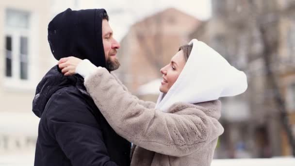 Schöne Männer und Frauen im Winter auf der Straße erfroren und setzten Kapuzen auf. — Stockvideo