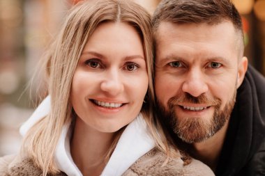 Yakın plan. Erkek ve kadın sokakta kış fotoğraf çekimi için poz veriyorlar. 