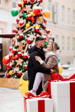 Erkek ve kadın kış fotoğraf çekimi için sokak ışıklarının ortasında poz veriyorlar. Bokeh