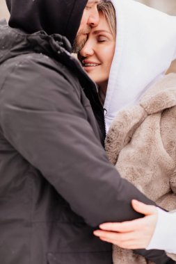 Mahalledeki kadın ve erkek sokakta kış fotoğraf çekimi için poz veriyor.