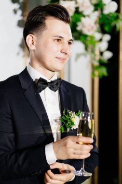 Şampanyalı yaka çiçekli damat tostları dinliyor.