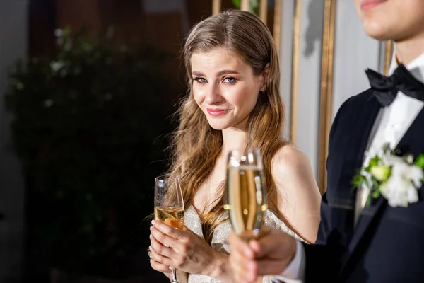 Зворушливий момент. молодята з шампанським слухайте привітання від гостей — стокове фото