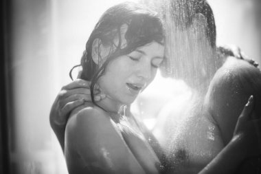 Siyah-beyaz. Yumuşak odaklanma. Erkek ve kadın pencereden ateş ederek duş alır..