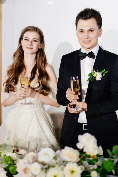 Friss házasok pezsgővel a kezükben hallgatják a köszöntőt, gratulálok a vendégeknek. — Stock Fotó