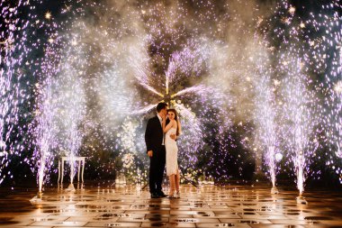 Gelin ve damat havai fişek çeşmesinin koridorunda duruyorlar.