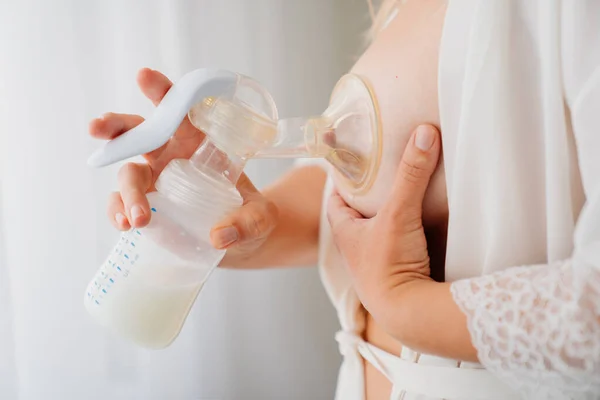 Bir kadın göğüs pompası kullanır. Gelişmiş emzirme, anne sütü arzı, beslenme. 