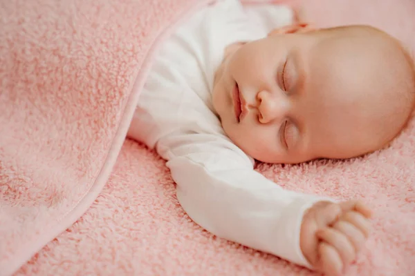 Sovande bebis under den rosa filten. hälsosam sömn hos nyfödda. — Stockfoto