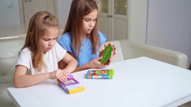 Kızlar bavullarını yeni geliştirme ve eğitim kartlarıyla açıyorlar. çocuklar için tahta oyunları.