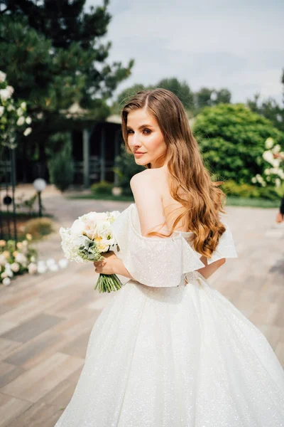 Braut. Eine schöne Frau in einem weißen Brautkleid mit wallenden Haaren — Stockfoto