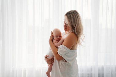 Anne ve bebek pencerede duruyor. Emzirdikten sonra..