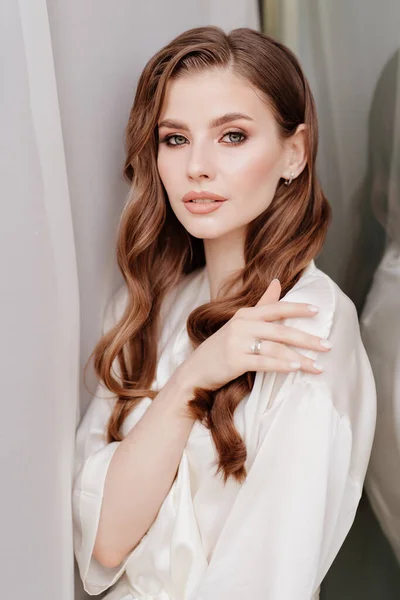 Belle femme en robe blanche à la fenêtre.matin de la mariée avant le mariage — Photo