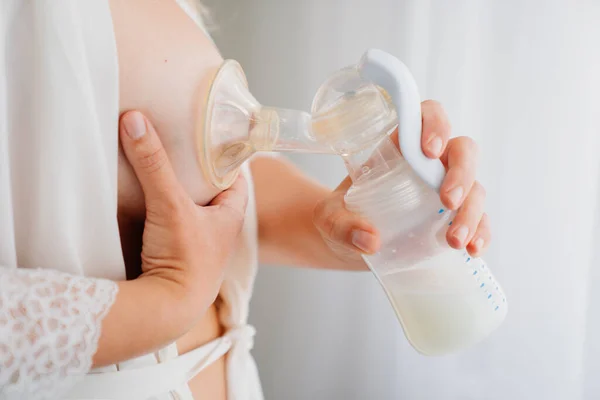 Bir kadın göğüs pompası kullanır. Gelişmiş emzirme, anne sütü arzı, beslenme. 