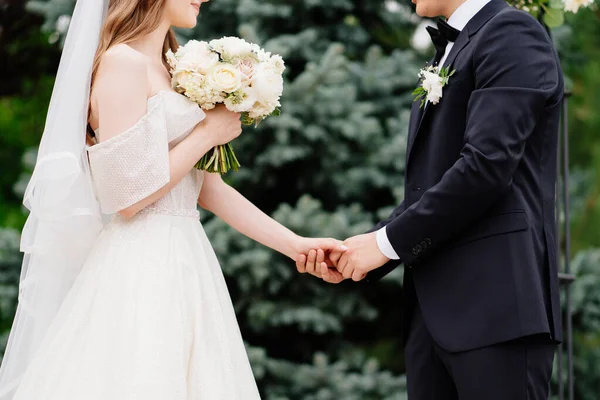 Trauung im Freien. Frischvermählte halten Händchen. glückliche Braut und Bräutigam. — Stockfoto