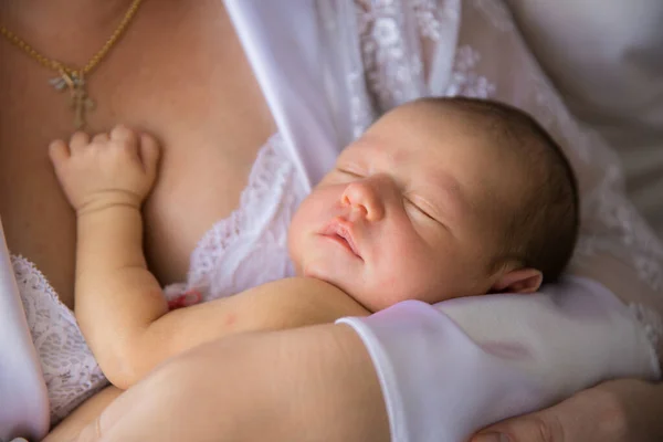 De cerca. un recién nacido duerme en brazos de su madre. —  Fotos de Stock