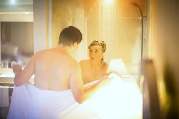 Foco suave. homem com toalha aberta na frente da mulher tomando banho no banheiro — Fotografia de Stock