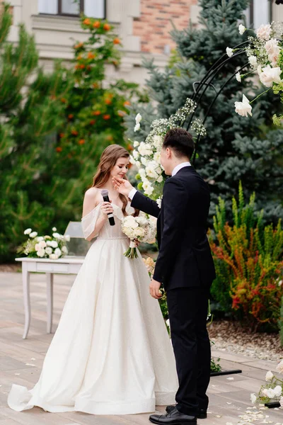 Cerimonia nuziale in arco di fiori vivi. sposa dice voto di nozze e piangere — Foto Stock