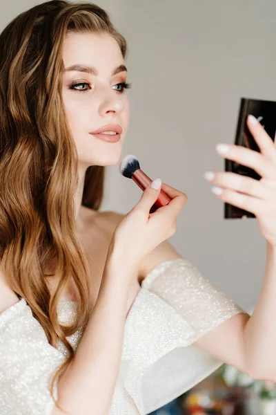 Beautiful young woman doing makeup. preparing the bride for the wedding. — Stock Photo, Image