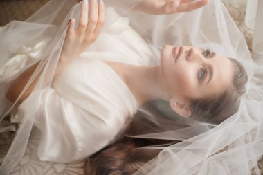 Bornozlu güzel bir kadın peçenin altında yatıyor..